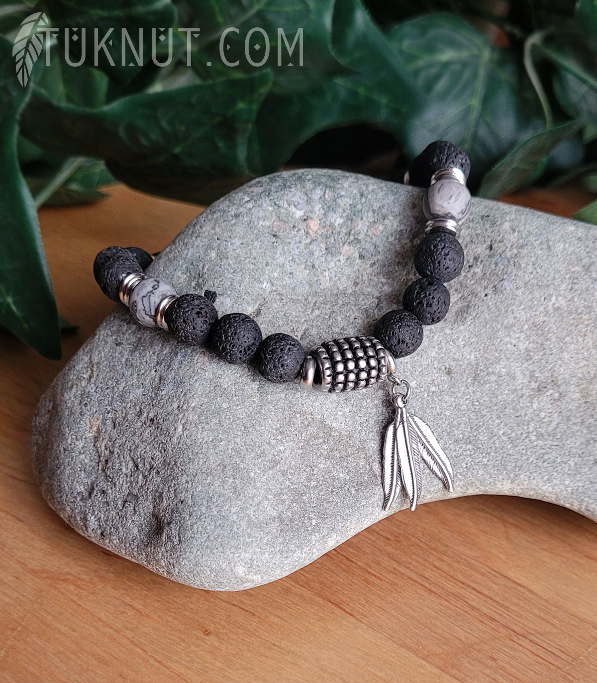 Bracelet d'inspiration autochtone (monté sur fil en acier inoxydable) avec pierre volcanique, jaspe; anneaux séparateurs et pendentifs (plumes) en acier inoxydable (couleurs : noir, gris et argent) TUKNUT
