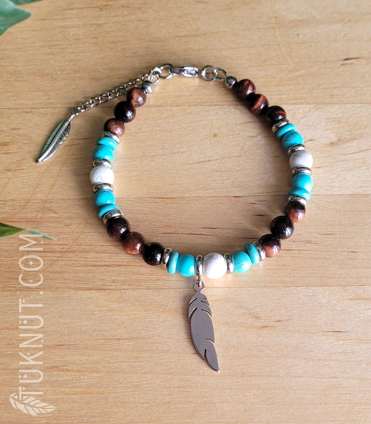 Bracelet d'inspiration autochtone (monté sur fil en acier inoxydable) avec oeil de tigre rouge, turquoise, howlite, billes séparatrices et pendentif (plume) en acier inoxydable (couleurs : brun-rouge, turquoise, blanc et argent) TUKNUT