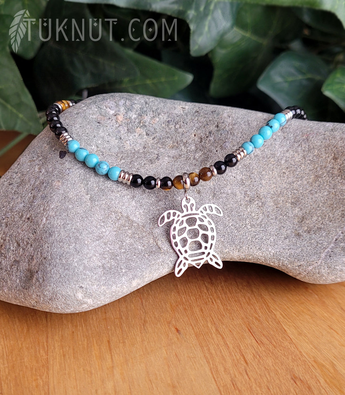 Collier d'inspiration autochtone (monté sur fil en acier inoxydable) avec turquoise, onyx et oeil de tigre, billes séparatrices, pendentif (tortue) et breloque (plume) en acier inoxydable (couleurs : noir, turquoise, brun et argent) TUKNUT