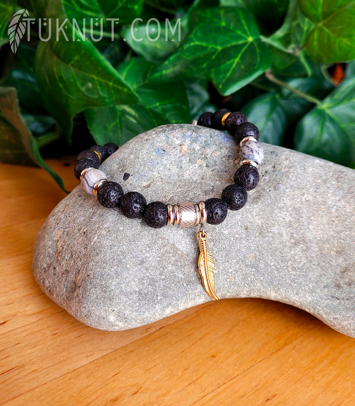 Bracelet d'inspiration autochtone (monté sur fil en acier inoxydable) avec pierre volcanique, jaspe; anneaux séparateurs et pendentif (Plume dorée) en acier inoxydable (couleurs : noir, gris, argent et or) TUKNUT
