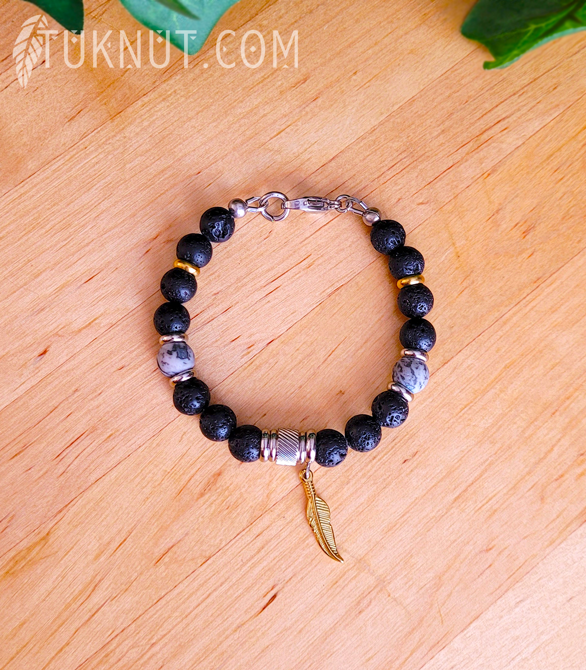 Bracelet d'inspiration autochtone (monté sur fil en acier inoxydable) avec pierre volcanique, jaspe; anneaux séparateurs et pendentif (Plume dorée) en acier inoxydable (couleurs : noir, gris, argent et or) TUKNUT