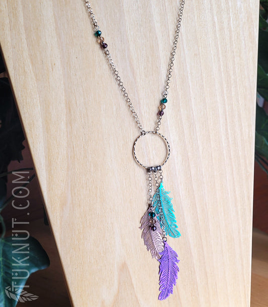 Collier d'inspiration autochtone avec pendentifs (plume) en acier inoxydable avec billes de cristal (couleurs : argent, vert, bronze et mauve) TUKNUT