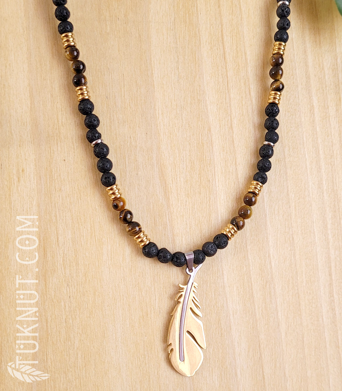 Collier d'inspiration autochtone avec pendentif (plume) en acier inoxydable avec pierre volcanique et oeil de tigre (couleurs : noir, brun, or et argent) TUKNUT