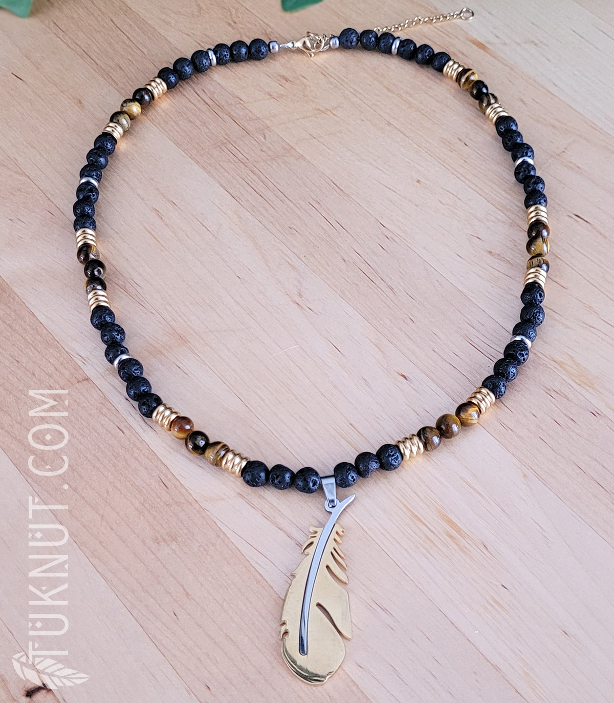 Collier d'inspiration autochtone avec pendentif (plume) en acier inoxydable avec pierre volcanique et oeil de tigre (couleurs : noir, brun, or et argent) TUKNUT